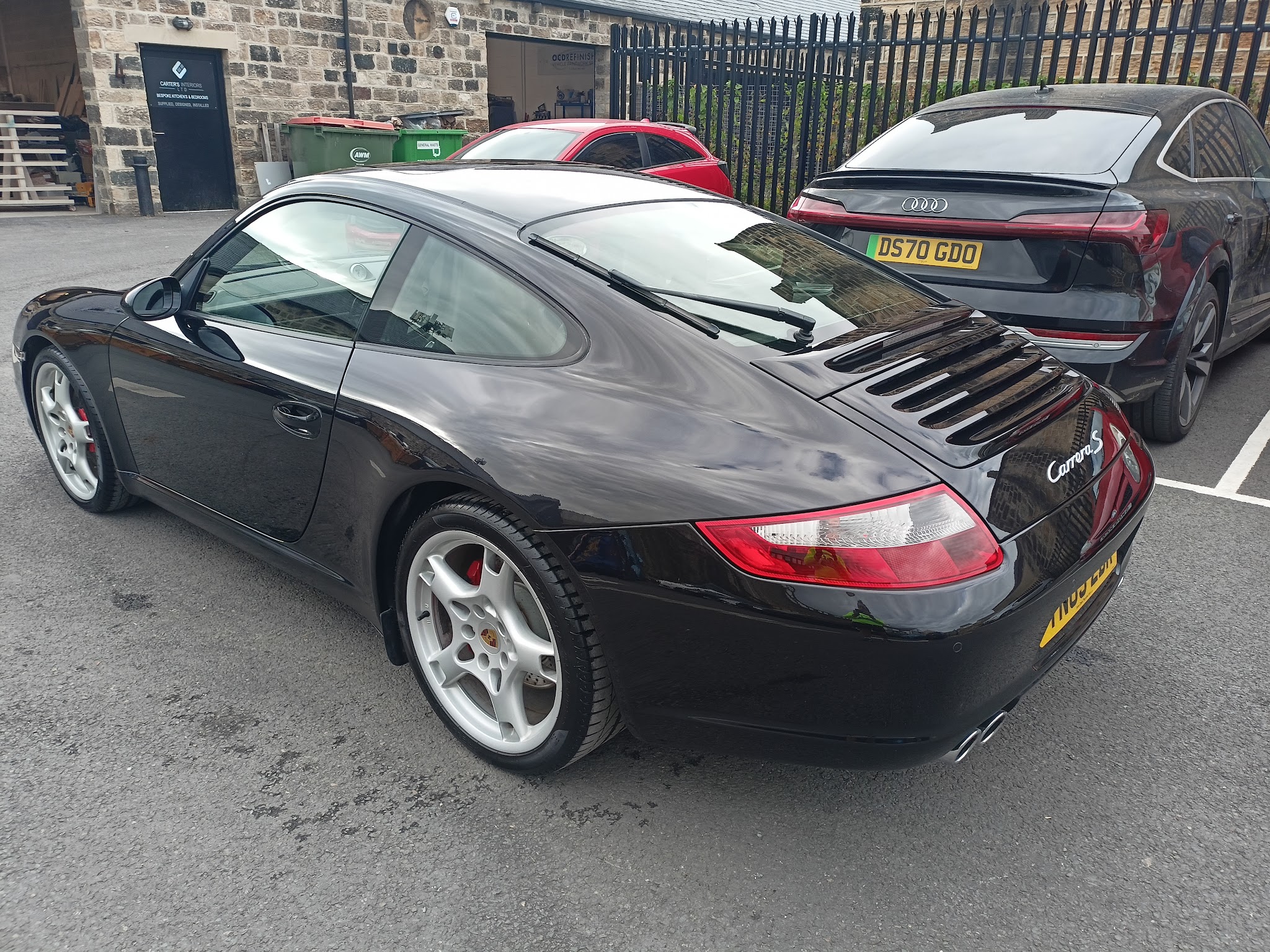 Black Porsche Carrera S outside the workshop
